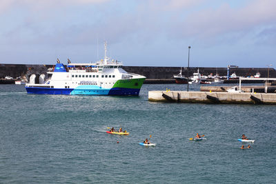 Boats moored at harbor against sky