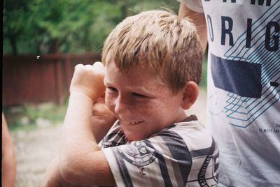 Close-up portrait of boy holding smart phone