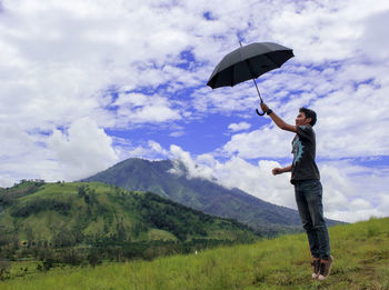 Full length of man standing on field against sky