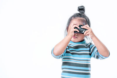 Boy holding camera over white background