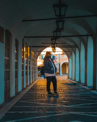 Rear view of woman standing on corridor of building