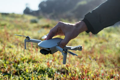 Midsection of man holding airplane on field