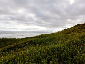 Scenic view of land and sea against sky