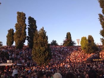 Group of people against clear blue sky