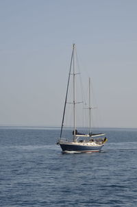 Sailboat sailing on sea against clear sky