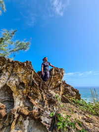 Low angle view of rock formation in sea against sky