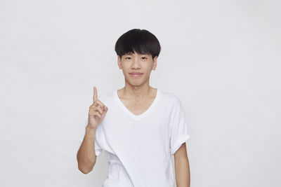 Portrait of smiling man standing against white background