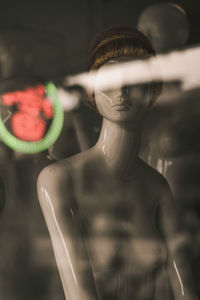 Close-up of mannequin in store seen through window