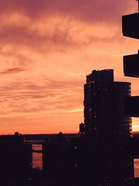 Low angle view of silhouette buildings against sky at sunset