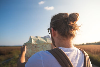 Rear view of man reading map