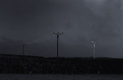 Electricity pylon on field against sky