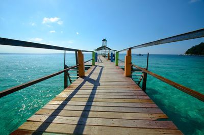 Pier over sea against blue sky