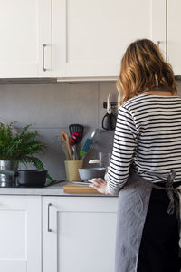 Rear view of woman standing at home