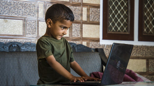 Boy looking at camera while sitting at home