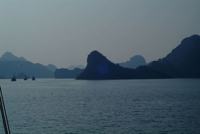 Scenic view of sea and mountains against clear sky