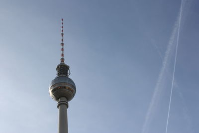 Low angle view of communications tower against blue sky