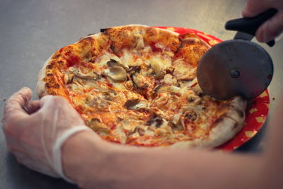 Close-up of hand holding pizza