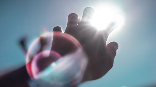 Close-up of hand against bright sun