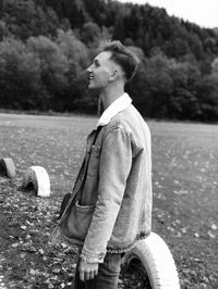 Young man looking away on field