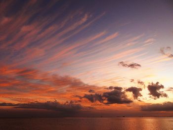 Scenic view of sea against dramatic sky during sunset