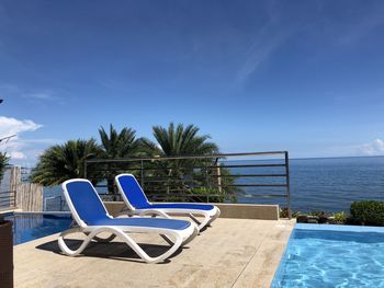 Empty chairs against blue sky