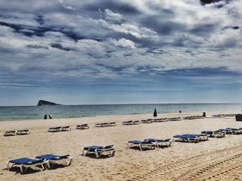 Scenic view of beach against cloudy sky