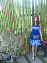 Portrait of young woman standing on bamboo in forest