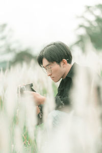 Portrait of man with his camera in the middle of white reeds