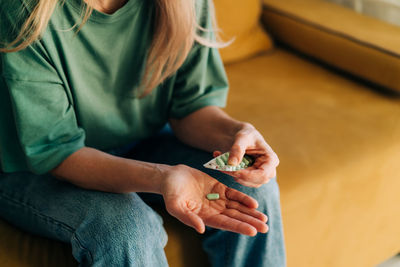 Close-up of a woman holding pills.