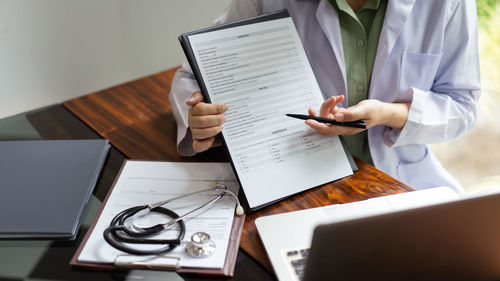 Midsection of doctor working on table