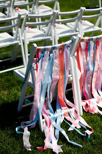 White chairs for a wedding ceremony on a green meadow with colorful stripes