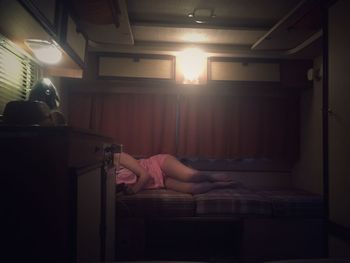 Woman sitting on bed at home