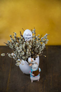 High angle view of flower vase with decorations on wooden table during easter