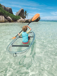 Rear view of woman on inflatable boat in sea