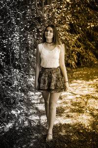 Young woman walking on field in park