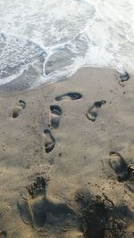 High angle view of footprints on sand at beach