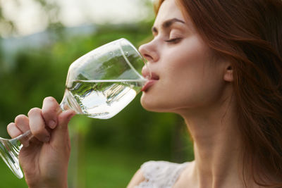 Close-up of woman drinking wine in glass