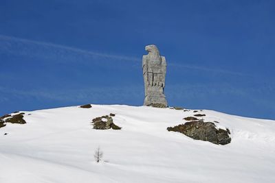 Snow covered landscape against blue sky