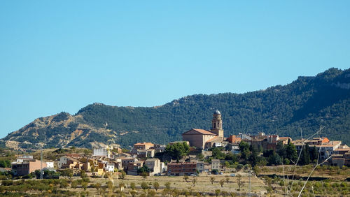 Houses and buildings against clear blue sky