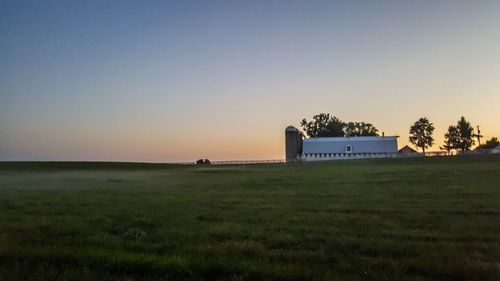 Scenic view of field against clear sky during sunset