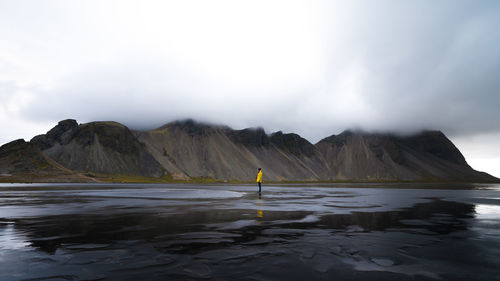 Full length of woman standing on field against mountain