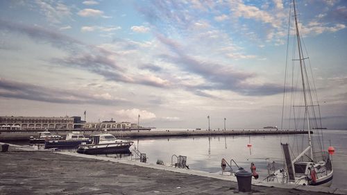 Boats moored at pier in sea against sky