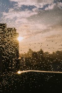 Raindrops on glass window during sunset