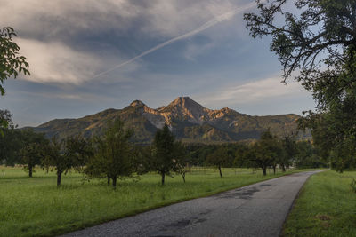 Scenic view of road by mountains against sky