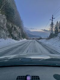 Snow covered road seen through car windshield