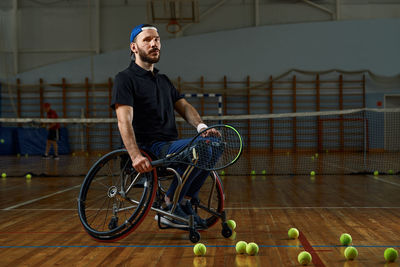 Portrait of boy playing with ball on tennis court