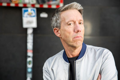 Portrait of man standing against wall