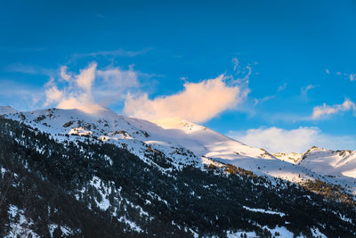 Snow capped mountain peaks illuminated by sunset light, andorra, pyrenees