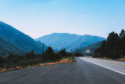 Road by mountains against sky