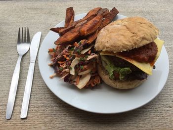 Close-up of burger and french fries in plate on table